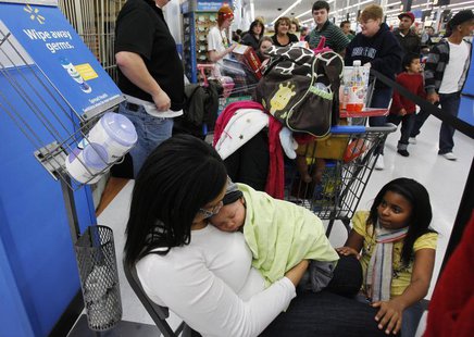 Shawna Ellis (L) cradles her two-month-old son Aiden as she and Tianna Rogers (R), 10, wait in line for a computer to go on sale at WalMart Shawna Ellis (L) cradles her two-month-old son Aiden as she and Tianna Rogers (R), 10, wait in line for a computer to go on sale at WalMart