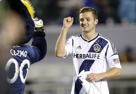 Los Angeles Galaxy midfielder Robbie Rogers (R) fist pumps the team's mascot Cozmo after playing in the second half of the MLS soccer game a Los Angeles Galaxy midfielder Robbie Rogers (R) fist pumps the team's mascot Cozmo after playing in the second half of the MLS soccer game a