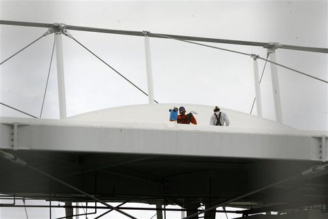 Men work on the roof of the Fonte Nova stadium after heavy rain in preparation for the 2013 Confederations Cup, in Salvador May 27, 2013. RE Men work on the roof of the Fonte Nova stadium after heavy rain in preparation for the 2013 Confederations Cup, in Salvador May 27, 2013. RE