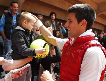 Novak Djokovic of Serbia signs autographs after a training session for the French Open tennis tournament at the Roland Garros stadium in Par Novak Djokovic of Serbia signs autographs after a training session for the French Open tennis tournament at the Roland Garros stadium in Par