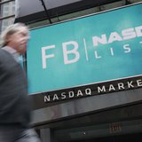 A man walks past a sign welcoming Facebook to the NASDAQ Marketsite in New York May 18, 2012. REUTERS/Brendan McDermid