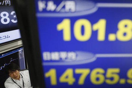 A employee of a foreign exchange trading company is seen between monitors displaying the Japanese yen's exchange rate against the U.S. dolla A employee of a foreign exchange trading company is seen between monitors displaying the Japanese yen's exchange rate against the U.S. dolla