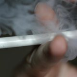 A man uses an E-cigarette, an electronic substitute in the form of a rod, slightly longer than a normal cigarette, in this illustration pict