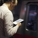 A commuter reads on his Kindle e-reader as a subway train arrives in Cambridge, Massachusetts, March 18, 2011. REUTERS/Brian Snyder