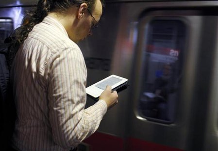 A commuter reads on his Kindle e-reader as a subway train arrives in Cambridge, Massachusetts, March 18, 2011. REUTERS/Brian Snyder A commuter reads on his Kindle e-reader as a subway train arrives in Cambridge, Massachusetts, March 18, 2011. REUTERS/Brian Snyder