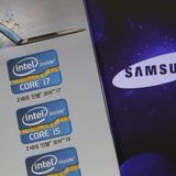 The Samsung Electronics logo is seen on a laptop computer screen (R) in front of an advertisement board promoting Intel processors at a stor