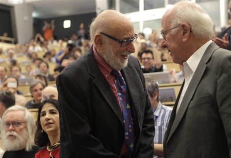 British physicist Peter Higgs (R) shakes hands with Belgium physicist Francois Englert before a scientific seminar to deliver the latest upd British physicist Peter Higgs (R) shakes hands with Belgium physicist Francois Englert before a scientific seminar to deliver the latest upd