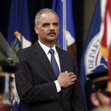 U.S. Attorney General Eric Holder puts his hand to his heart during the national anthem as he hosts a special naturalization ceremony at the