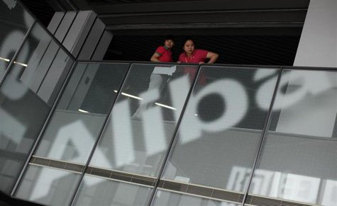 Employees stand next to a logo of Alibaba (China) Technology Co. Ltd during a media tour organized by government officials at its headquarte Employees stand next to a logo of Alibaba (China) Technology Co. Ltd during a media tour organized by government officials at its headquarte