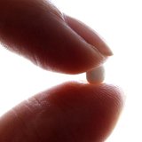 An illustration picture shows a woman holding a birth control pill at her home in Nice January 3, 2013. REUTERS/Eric Gaillard