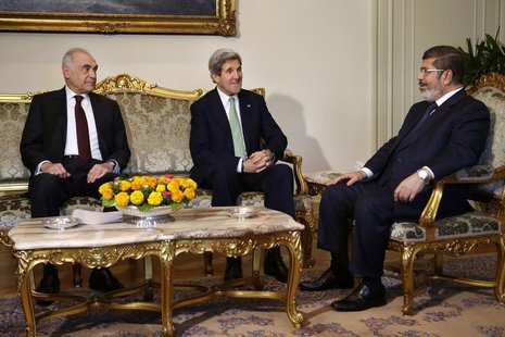 Egyptian Foreign Minister Mohammed Kamel Amr (L), sits with U.S. Secretary of State John Kerry, and Egyptian President Mohamed Mursi (R) dur Egyptian Foreign Minister Mohammed Kamel Amr (L), sits with U.S. Secretary of State John Kerry, and Egyptian President Mohamed Mursi (R) dur