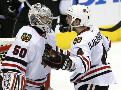 Chicago Blackhawks defenseman Niklas Hjalmarsson (4) celebrates with goalie Corey Crawford (50) after defeating the Los Angeles Kings in Gam Chicago Blackhawks defenseman Niklas Hjalmarsson (4) celebrates with goalie Corey Crawford (50) after defeating the Los Angeles Kings in Gam