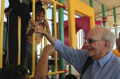 Executive Director of the United Nations Children's Fund (UNICEF) Anthony Lake smiles as he fist bumps with Syrian children during a visit t Executive Director of the United Nations Children's Fund (UNICEF) Anthony Lake smiles as he fist bumps with Syrian children during a visit t