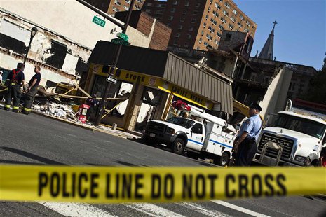A police officer stands guard while rescue workers and firefighters search through rubble following a building collapse in Philadelphia June A police officer stands guard while rescue workers and firefighters search through rubble following a building collapse in Philadelphia June