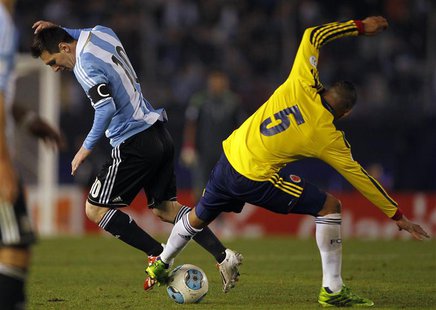 Lionel Messi (L) of Argentina tries to dribbles the ball under pressure from Aldo Ramirez of Colombia during their 2014 World Cup qualifying Lionel Messi (L) of Argentina tries to dribbles the ball under pressure from Aldo Ramirez of Colombia during their 2014 World Cup qualifying