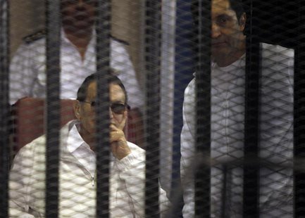 Egypt's ousted President Hosni Mubarak (L) sits near his son Alaa behind bars during their trial inside a dock at the police academy, on the Egypt's ousted President Hosni Mubarak (L) sits near his son Alaa behind bars during their trial inside a dock at the police academy, on the