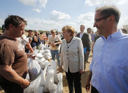 German Chancellor Angela Merkel and Brandenburg State Premier Matthias Platzeck (R) meet volunteers reinforcing a dyke at the bank of the ri German Chancellor Angela Merkel and Brandenburg State Premier Matthias Platzeck (R) meet volunteers reinforcing a dyke at the bank of the ri