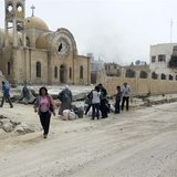 Residents walk near a damaged church as they are seen in Qusair to inspect their houses and collect their belongings June 8, 2013. REUTERS/R Residents walk near a damaged church as they are seen in Qusair to inspect their houses and collect their belongings June 8, 2013. REUTERS/R