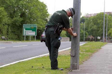 A Police Service of Northern Ireland officer seals a lampost along the road to the Lough Erne Golf Resort where the G8 summit will be held n A Police Service of Northern Ireland officer seals a lampost along the road to the Lough Erne Golf Resort where the G8 summit will be held n