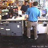 This surveillance photo shows a man (in black, facing the camera) suspected of stealing a minivan with a child inside from a parking lot in Fond du Lac on June 10, 2013. This surveillance photo shows a man (in black, facing the camera) suspected of stealing a minivan with a child inside from a parking lot in Fond du Lac on June 10, 2013.