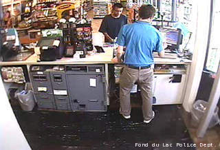 This surveillance photo shows a man (in black, facing the camera) suspected of stealing a minivan with a child inside from a parking lot in Fond du Lac on June 10, 2013. This surveillance photo shows a man (in black, facing the camera) suspected of stealing a minivan with a child inside from a parking lot in Fond du Lac on June 10, 2013.