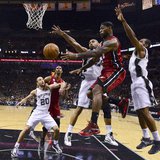 Miami Heat LeBron James (2nd R) has to pass off as San Antonio Spurs Tim Duncan (C) and Kawhi Leonard (R) defend during Game 3 of their NBA 