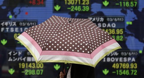 A woman with an umbrella walks past a stock index board showing various countries' stock price index outside a brokerage in Tokyo June 12, 2 A woman with an umbrella walks past a stock index board showing various countries' stock price index outside a brokerage in Tokyo June 12, 2