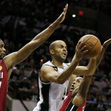 San Antonio Spurs' Tony Parker drives to the net between Miami Heat's Chris Bosh (L) and Mario Chalmers during the first quarter in Game 3 o San Antonio Spurs' Tony Parker drives to the net between Miami Heat's Chris Bosh (L) and Mario Chalmers during the first quarter in Game 3 o