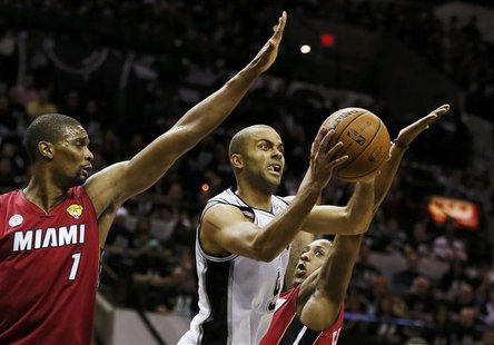 San Antonio Spurs' Tony Parker drives to the net between Miami Heat's Chris Bosh (L) and Mario Chalmers during the first quarter in Game 3 o San Antonio Spurs' Tony Parker drives to the net between Miami Heat's Chris Bosh (L) and Mario Chalmers during the first quarter in Game 3 o