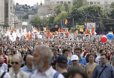 Participants hold portraits of detained activists and wave flags during an opposition protest march in Moscow, June 12, 2013. REUTERS/Sergei Participants hold portraits of detained activists and wave flags during an opposition protest march in Moscow, June 12, 2013. REUTERS/Sergei