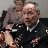An aide (L) takes notes as U.S. General Keith Alexander, director of the National Security Agency (NSA) and U.S. Cyber Command, speaks to re