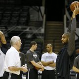 San Antonio Spurs coach Gregg Popovich (2nd L) speaks with player Tim Duncan (R) as teammate Tracy McGrady (L) warms up during practice for 