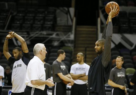 San Antonio Spurs coach Gregg Popovich (2nd L) speaks with player Tim Duncan (R) as teammate Tracy McGrady (L) warms up during practice for San Antonio Spurs coach Gregg Popovich (2nd L) speaks with player Tim Duncan (R) as teammate Tracy McGrady (L) warms up during practice for