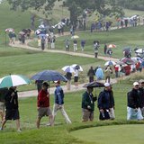Spectators walk in the rain during a practice round for the 2013 U.S. Open golf championship at the Merion Golf Club in Ardmore, Pennsylvani
