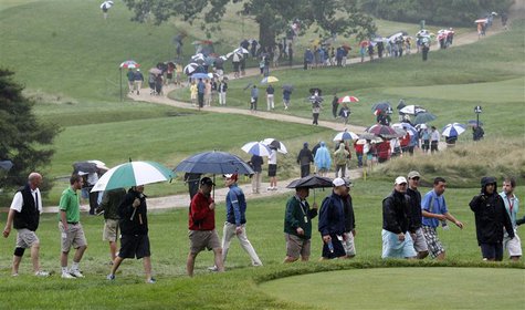 Spectators walk in the rain during a practice round for the 2013 U.S. Open golf championship at the Merion Golf Club in Ardmore, Pennsylvani Spectators walk in the rain during a practice round for the 2013 U.S. Open golf championship at the Merion Golf Club in Ardmore, Pennsylvani