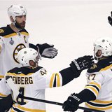 Boston Bruins' Milan Lucic (R) is congratulated by teammates Zdeno Chara (L) and Dennis Seidenberg after scoring on the Chicago Blackhawks d