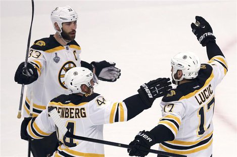 Boston Bruins' Milan Lucic (R) is congratulated by teammates Zdeno Chara (L) and Dennis Seidenberg after scoring on the Chicago Blackhawks d Boston Bruins' Milan Lucic (R) is congratulated by teammates Zdeno Chara (L) and Dennis Seidenberg after scoring on the Chicago Blackhawks d