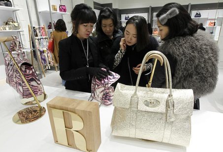A saleswoman for British fashion brand Mulberry talks about one of the brand's bags to customers at a shop at Lotte Premium Outlets in Paju, A saleswoman for British fashion brand Mulberry talks about one of the brand's bags to customers at a shop at Lotte Premium Outlets in Paju,