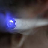 A man uses an E-cigarette, an electronic substitute in the form of a rod, slightly longer than a normal cigarette, in this illustration pict A man uses an E-cigarette, an electronic substitute in the form of a rod, slightly longer than a normal cigarette, in this illustration pict