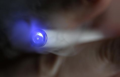 A man uses an E-cigarette, an electronic substitute in the form of a rod, slightly longer than a normal cigarette, in this illustration pict A man uses an E-cigarette, an electronic substitute in the form of a rod, slightly longer than a normal cigarette, in this illustration pict
