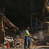 A construction worker walks near the debris following a building collapse in Philadelphia June 5, 2013. REUTERS/Eduardo Munoz