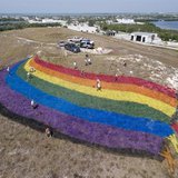 Landscape "artists" put finishing touches on a giant rainbow flag on the top of a dormant landfill, nicknamed Mount Trashmore, in Key West, Landscape "artists" put finishing touches on a giant rainbow flag on the top of a dormant landfill, nicknamed Mount Trashmore, in Key West,