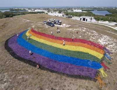 Landscape "artists" put finishing touches on a giant rainbow flag on the top of a dormant landfill, nicknamed Mount Trashmore, in Key West, Landscape "artists" put finishing touches on a giant rainbow flag on the top of a dormant landfill, nicknamed Mount Trashmore, in Key West,