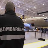 A security guard looks on as Bombardier unveiled its CSeries aircraft at a news conference at its assembly facility in Mirabel, Quebec, Marc