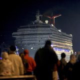 The Carnival Triumph cruise ship is towed towards the dock as spectators watch at the port of Mobile, Alabama, February 14, 2013. REUTERS/ L The Carnival Triumph cruise ship is towed towards the dock as spectators watch at the port of Mobile, Alabama, February 14, 2013. REUTERS/ L
