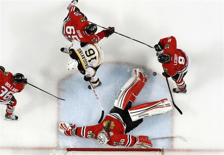 Chicago Blackhawks goalie Corey Crawford (50) makes a save on Boston Bruins left wing Kaspars Daugavins (16) during Game 1 of their NHL Stan Chicago Blackhawks goalie Corey Crawford (50) makes a save on Boston Bruins left wing Kaspars Daugavins (16) during Game 1 of their NHL Stan