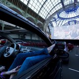 Visitors watch a film as they attend the opening night of a drive-in cinema, which will run till June 21, at the Grand Palais in Paris June 