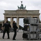 Police officers with their sniffer dog check parts of stage for the podium where U.S. President Barack Obama will give a speech in front of Police officers with their sniffer dog check parts of stage for the podium where U.S. President Barack Obama will give a speech in front of