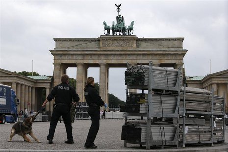 Police officers with their sniffer dog check parts of stage for the podium where U.S. President Barack Obama will give a speech in front of Police officers with their sniffer dog check parts of stage for the podium where U.S. President Barack Obama will give a speech in front of