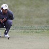 Tiger Woods of the U.S. looks at his birdie putt on the 13th green during completion of the weather delayed first round of the 2013 U.S. Ope